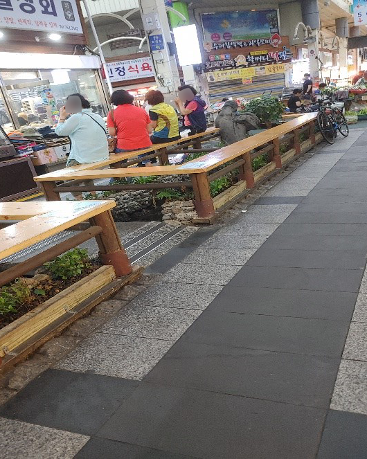 시장 내 사람들이 의자에 앉아 있는 사진입니다
