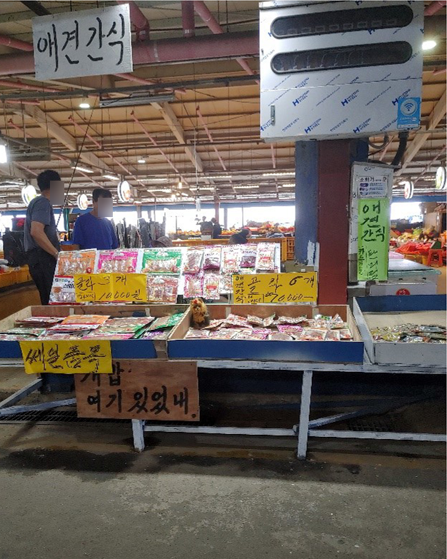 애견간식을 판매하는 코너입니다. 남자 두분이 앞에 서서 이야가를 나누고 있습니다.