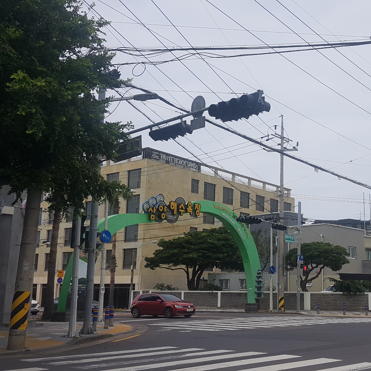 삼양해수욕장 입간판 사진입니다. 사거리에 삼양해수욕장 접근로를 알리는 커다란 터널형 간판이 있습니다.