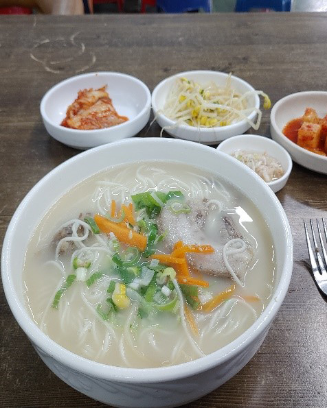 고기국수 사진입니다. 하얀국물에 고기와 면이 있습니다.