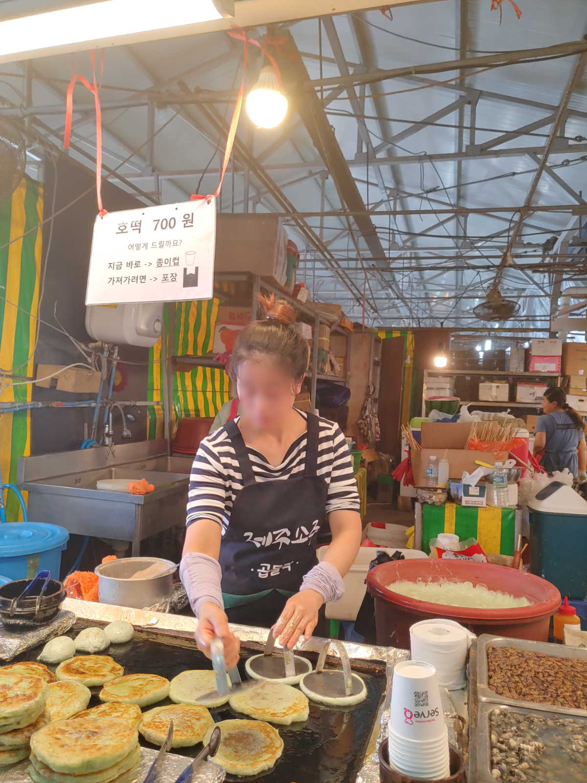 호떡을 굽는 모습입니다. 앞에 호떡이 쌓여있습니다.