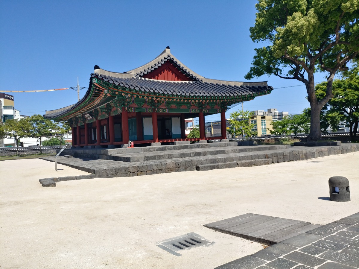 제주목관아의 기와집을 옆에서 본 모습입니다 돌로된 계단과 그 위에 여닫이문이 열려있습니다.