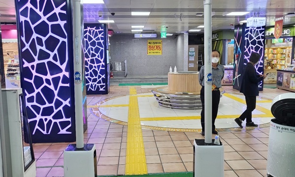 지하상가 내 만남의 광장에서 공기청정기와 사람 두명이 있는 사진입니다.