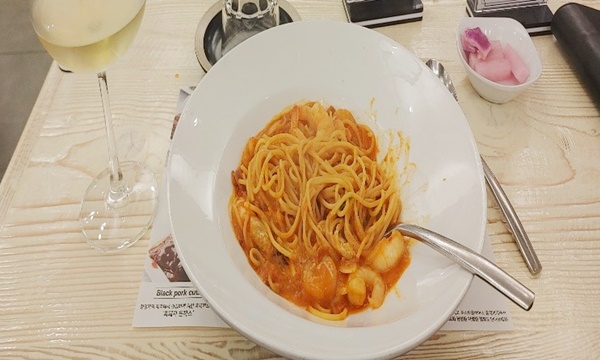 테이블 위에 파스타에 포크가 올려져있는 사진입니다.