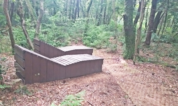숲길 안에 조성된 쉼터 내 나무베드가 2개 보이는 사진입니다.