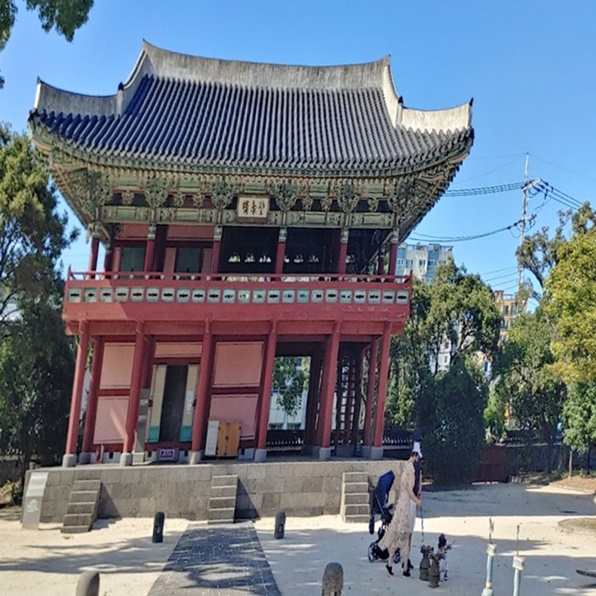 제주목 관아 내부에 건물 1개와 유아차, 사람2명이 보이는 사진입니다.
