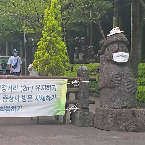 코로나 확산 방지를 위한 권고 사항 현수막입니다. 돌하르방에도 마스크를 쓰고 있습니다.