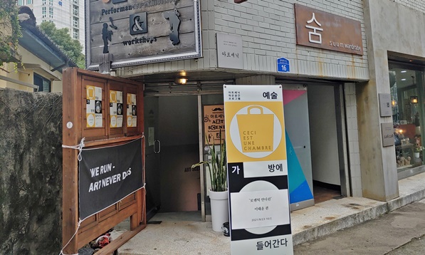 예술인의 거리 갤러리입니다. 배너가 입구에 놓여 있습니다. 배너에는 예술, '방에 들어간다' 라고 적혀 있습니다.
