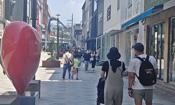 유아차를 끌며 칠성로를 걷는 부부 사진입니다.